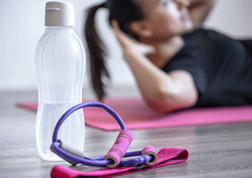botella-de-agua-y-una-banda-elastica-para-fitness-sobre-un-fondo-borroso 1